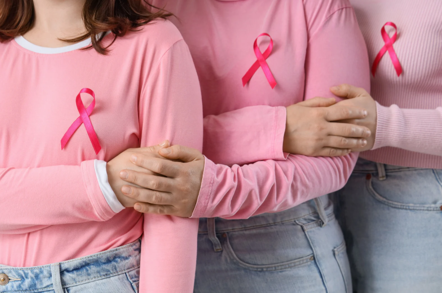 People wearing pink sweaters and breast cancer awareness ribbons